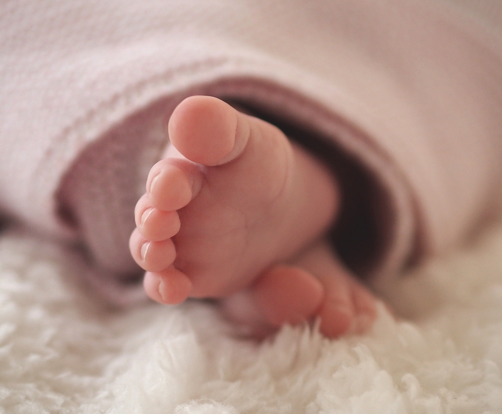 Kleine Neigeborenen Babyfüsschen in einer Decke.